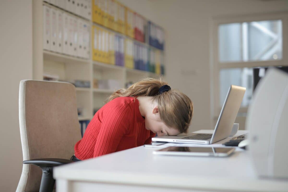 une femme fatiguée, la tête sur son ordinateur